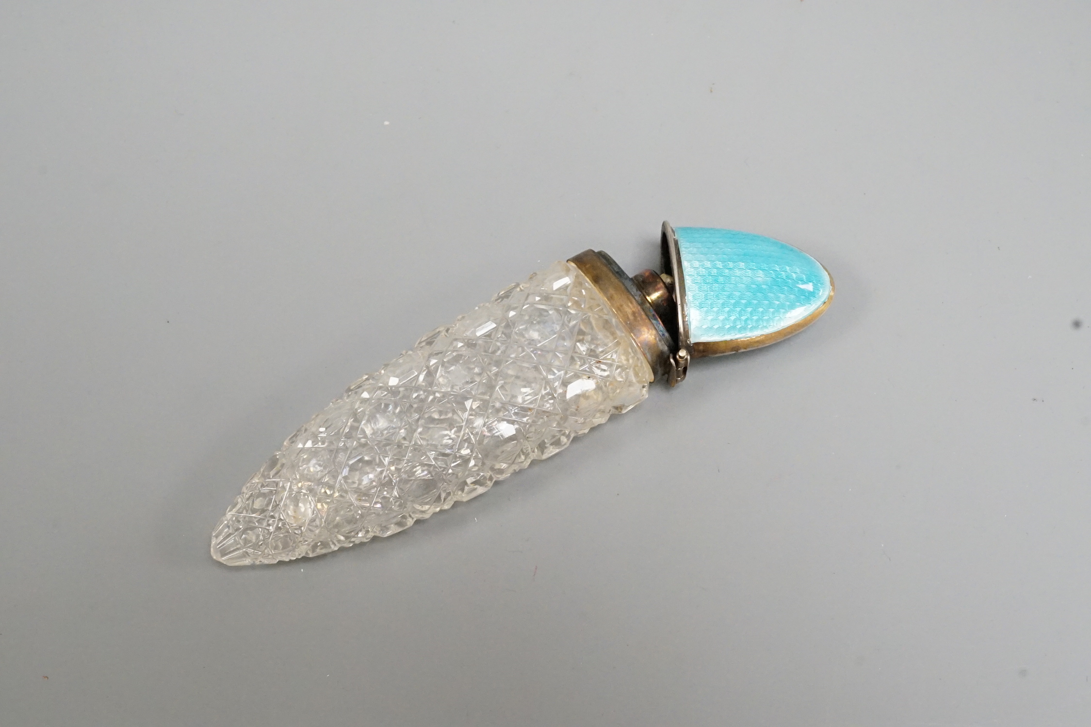 An early 20th century silver and blue enamel mounted cut glass scent bottle, Birmingham, date letter rubbed, 12cm.